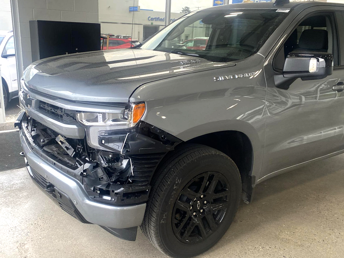 Gray Chevrolet Silverado with front-end collision damage and removed front bumper before repair at Al Serra Body Shop in Grand Blanc, MI